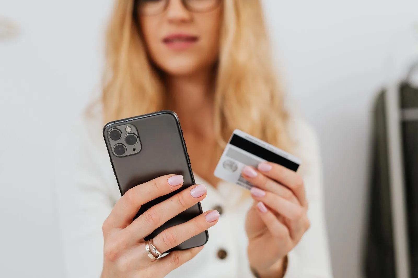 Bir elinde telefon, diğer elinde kredi kartı tutan kadın