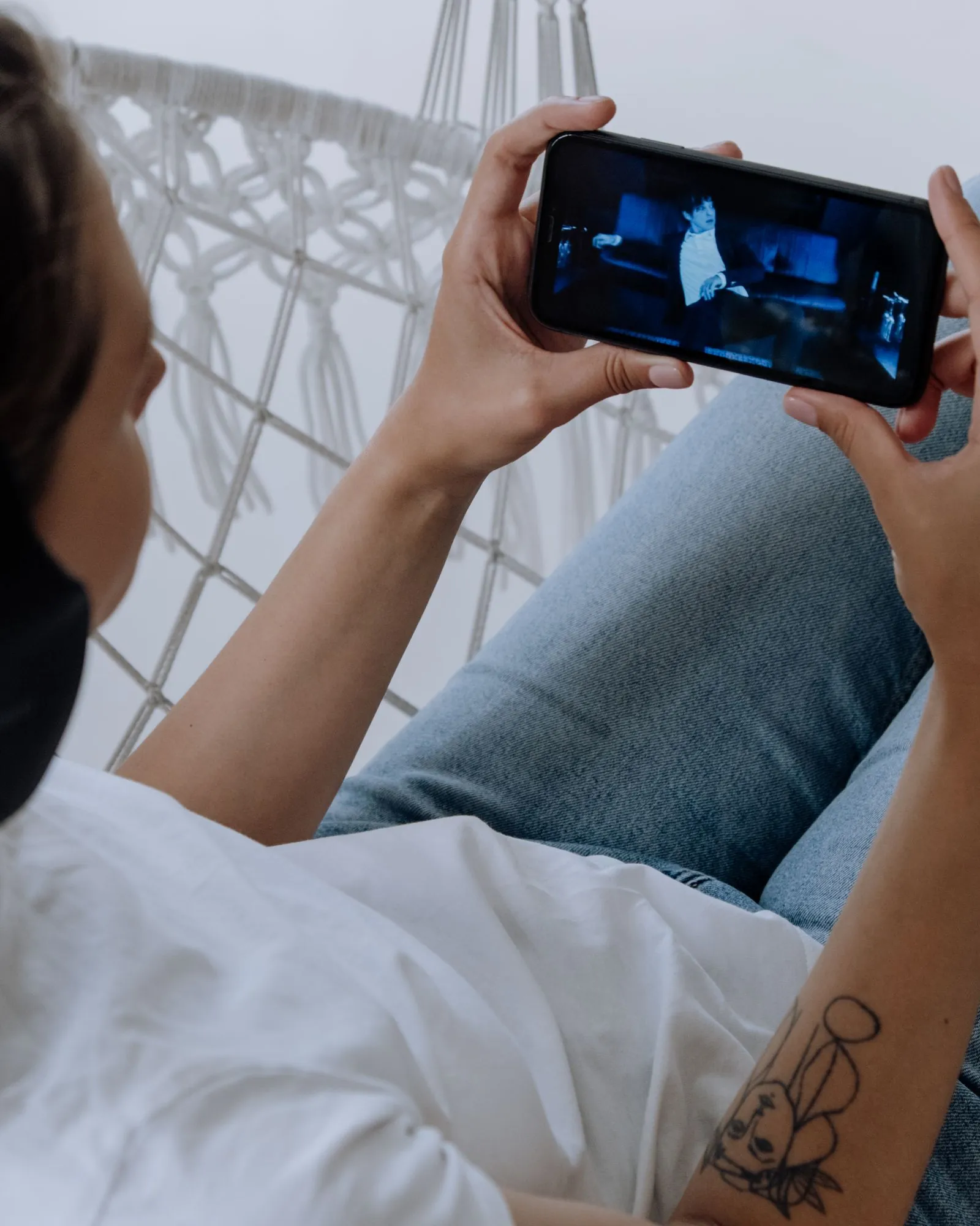 Telefonunda video izleyen kişi